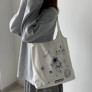 Detail showing the large capacity of a white canvas tote bag with hand-drawn space patterns