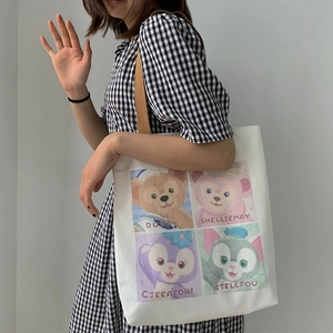 Borsa tote in tela bianca con stampe di animali e tracolla marrone indossata da modella