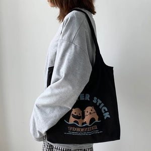 Detailansicht der schwarzen Segeltuchtasche mit süßem Seeotter-Motiv und Schriftzug