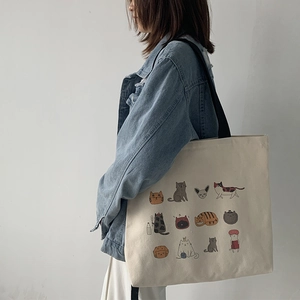 Vue latérale du sac fourre-tout en toile avec sangle noire et 12 motifs de chats mignons