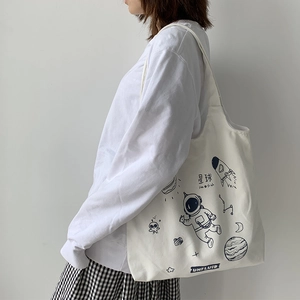 White canvas tote bag featuring blue space astronaut print and large storage capacity