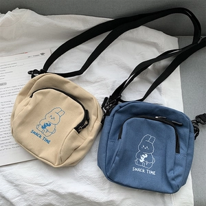 Detail of small canvas crossbody bags featuring cute rabbit prints and black straps