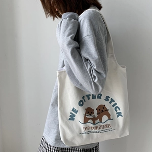 Seitenansicht der beigen Canvas-Einkaufstasche mit Ottermotiv und englischem Schriftzug
