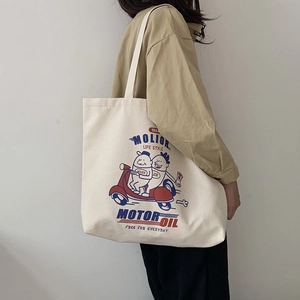 Side view of a large cream canvas tote bag with retro American cartoon motorcycle print