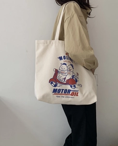 Close-up of retro cartoon illustration on off-white canvas tote bag worn by a model