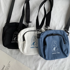 Three canvas crossbody bags in black white and denim blue featuring cute cartoon rabbit