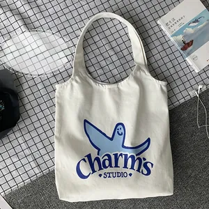 Detail showing high-quality canvas fabric with blue smile print on beige tote bag