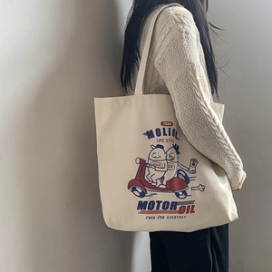 Detail of off-white canvas tote bag featuring vintage cartoon print and long shoulder straps