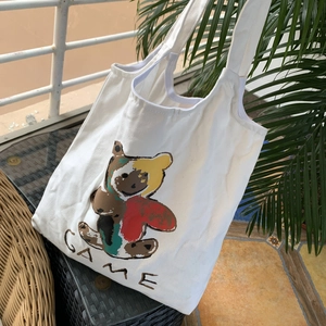 Détail du cabas en toile blanche avec motif ours coloré et texte GAME artistique