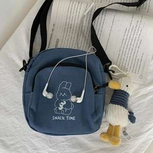 Blue canvas crossbody bag with white rabbit print and yellow duck plush keychain detail