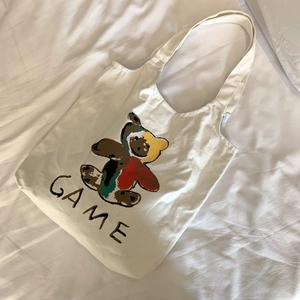 Détail du sac fourre-tout en toile blanche avec ours coloré et lettrage GAME stylé