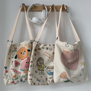 Détail de trois sacs cabas en toile avec imprimés de dessins animés et bandoulières réglables