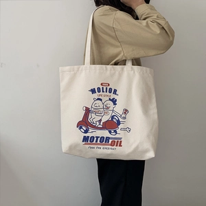 Detail of canvas tote bag with retro motor oil illustration and sturdy shoulder strap
