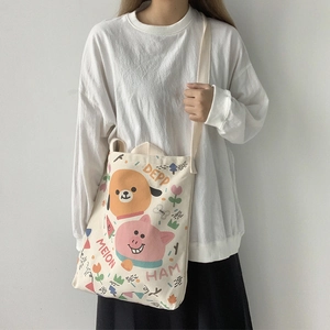 Détail d'un sac en toile avec illustration de chien et cochon et bandoulière souple