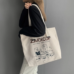 Detail of canvas tote bag with panda family print and ZARXCOP lettering on off-white fabric