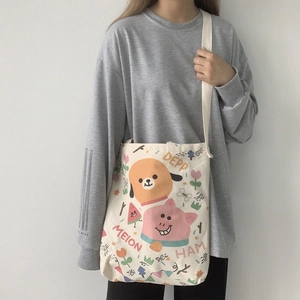 Détail du sac bandoulière en toile beige avec des illustrations de chiens et cochons colorés