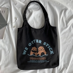 Flache Ansicht der schwarzen Segeltuchtasche mit Ottern und WE OTTER STICK TOGETHER Motiv