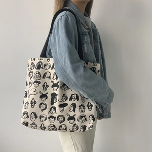 Artistic tote bag detail showing black facial line art pattern and wide strap