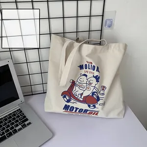 Detail of off-white canvas tote bag featuring vintage motor oil illustration and sturdy straps