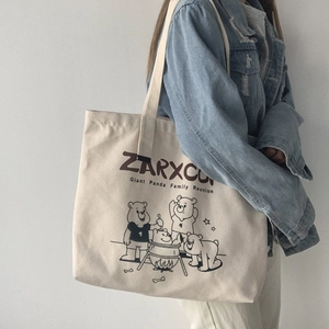 Detail of a large canvas tote bag featuring a cute panda family illustration and text
