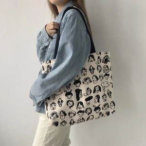 Artistic canvas tote bag with black face sketches and wide black shoulder straps