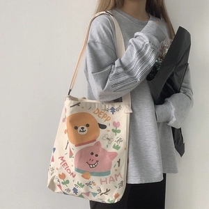 Détail du sac cabas en toile blanc cassé avec imprimé animal mignon et texte artistique