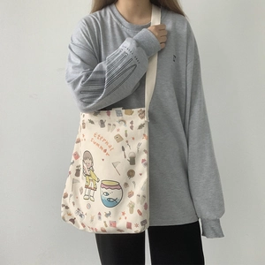 Détail du sac bandoulière en toile crème avec illustration et sangle en toile tissée