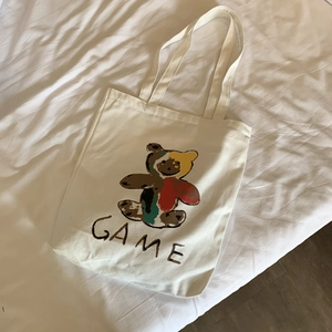 Détail d'un sac cabas en toile crème avec motif d'ours mignon et lettrage GAME