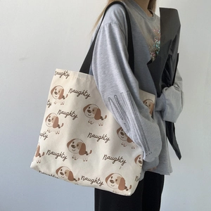 Borsa tote in tela bianco sporco con stampa di cani e tracolla nera su modella