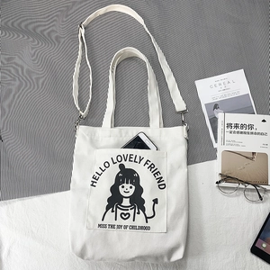 Detailed view of white canvas tote with cartoon girl illustration and adjustable strap