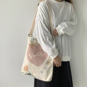 Détail du sac fourre-tout en toile crème avec motifs de cœurs roses et ours de dessin animé