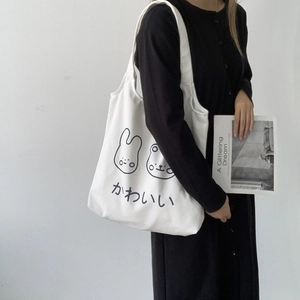 Detail of white canvas tote bag with cute cartoon animal prints and Japanese text
