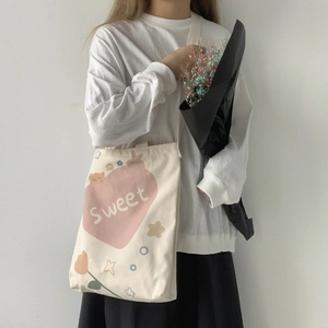 Détail du sac fourre-tout en toile crème avec cœur rose et illustration d'ours dessin