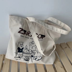 Detail of canvas tote bag with ZARA COP text and cartoon panda family printing