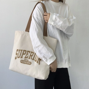 Detail of vintage canvas tote bag with brown straps and Superior lettering design
