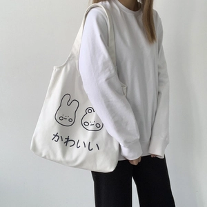 Detail of white canvas tote bag with cute cartoon bunny print and Japanese text