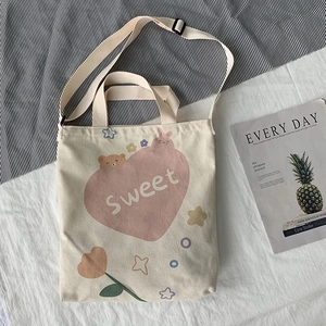Détail du sac cabas en toile crème avec cœur rose et bandoulière réglable pratique
