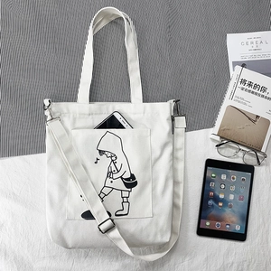 Detailed shot of white canvas tote bag with girl print and adjustable shoulder strap