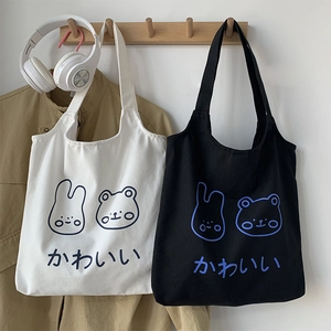 Detail of white and black Japanese canvas bags with cute rabbit and bear illustrations