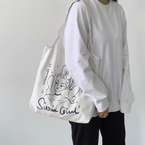 Dettaglio della grande borsa tote in tela bianca con illustrazione di ragazza e cigno