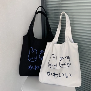Detail of canvas tote bags in black and cream featuring cute cartoon bunny and bear prints