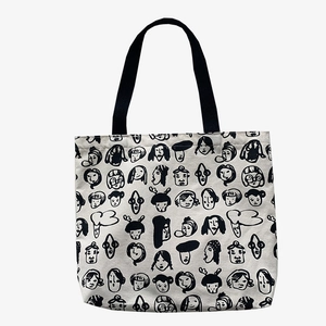 Artistic face print canvas tote bag with black handles on a clean white background