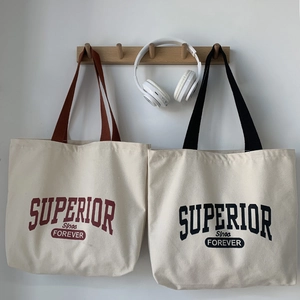 Detail of canvas tote bags with contrast straps and Superior Forever vintage lettering