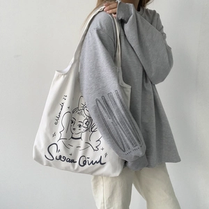 Dettaglio borsa tote in tela crema con illustrazione di moda e scritta Swan Girl chic