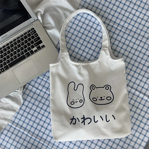 Detail of white canvas tote bag featuring cute cartoon rabbit and bear print motifs