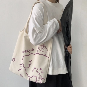Close-up of off-white canvas tote bag featuring purple cartoon puppy and LOVELY:D text
