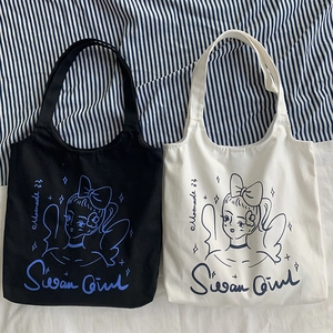 Dettaglio delle borse tote in tela nera e crema con illustrazioni artistiche stile vintage