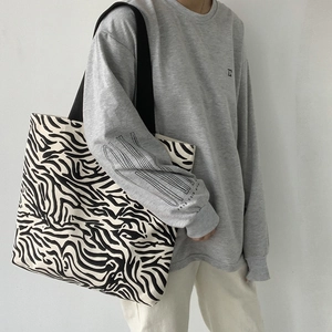 Vue détaillée du grand sac cabas en toile à motif zèbre avec anses noires tressées