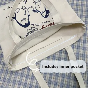 Detail view of the beige canvas tote bag showing the zipper closure and functional inner pocket