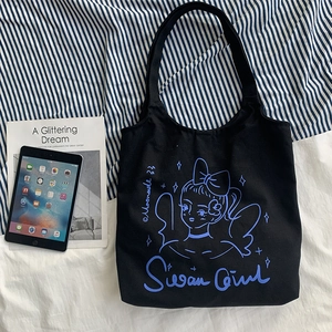 Dettaglio della borsa tote in tela nera con illustrazione Swan Girl blu e tessuto robusto